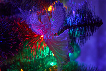 night angel on the Christmas tree,Christmas angel at night hanging on a Christmas tree glowing in colorful garlands