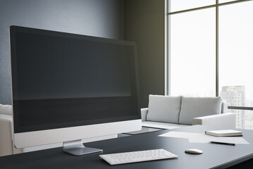 Designer desktop with blank black computer screen