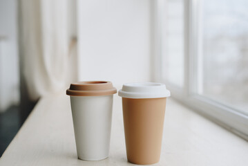 Fototapeta na wymiar two cups of coffee on the white windowsill