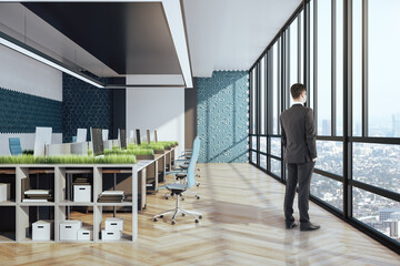 Businessman standing in coworking eco office interior
