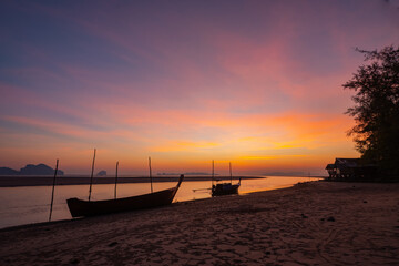 Fisherman boat on the tropical beach at sunset