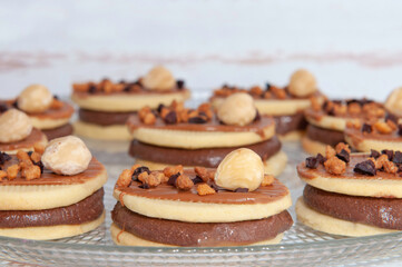 sandwich cookies with chocolate cream and fruit on transparent plate
