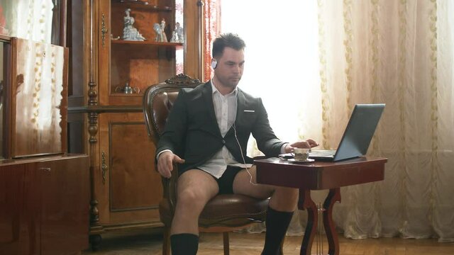 businessman from home working half-dressed in a suit and underpants, shows a class sign