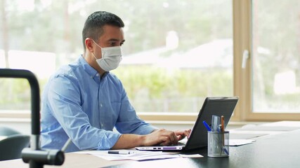 quarantine, remote job and pandemic concept - middle-aged man wearing face protective medical mask for protection from virus disease with laptop computer working at home office