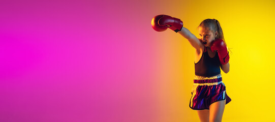 Little girl, kick boxer on gradient background in neon light, active and expressive. Concept of motion, action, motivation, childhood. Training winner, emotional. Sales, ad, flyer with copyspace.