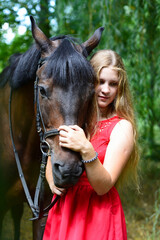 Obraz premium outdoor portrait of young beautiful woman with horse. Against the background of a tree