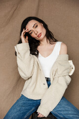 Photo of seductive young woman looking at camera while sitting on chair