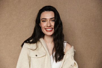Photo of joyful young woman in jacket laughing and looking at camera