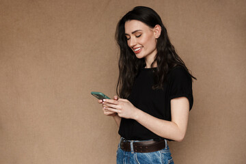 Photo of beautiful young brunette woman smiling and holding cellphone