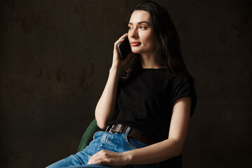 Photo of beautiful woman sitting on chair and talking on cellphone