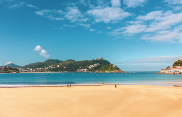 Wide beach of Biscay Bay. San Sebastian landmark, Basque Country, Spain. Scenic coastline with tourists. Promenade along the beach with waves. Travel and recreation concept. Aerial seascape in Europe.