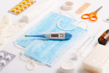 Medical protective mask, thermometer and medicine tablets in a blister isolated on a white background. Close up