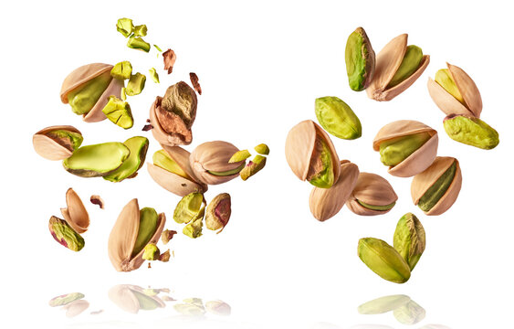 A set with Flying in air fresh raw whole and cracked pistachios  isolated on white background. Concept of Pistachios is torn to pieces close-up. High resolution image