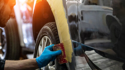 Auto mechanic working on car paint sanding in mechanics garage. workshop repair service. authentic...