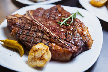 Medium rare t-bone steak cooked on grill pan in American restaurant.Delicious beefsteak piece on...