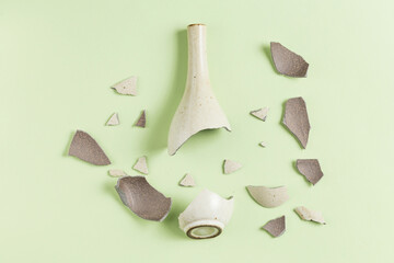 A broken vase against a green background