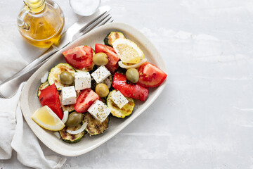 salad with fresh and grilled salad on white dish on gray ceramic background