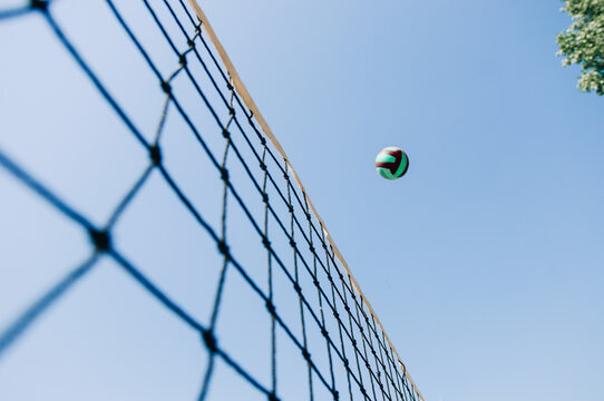 Beach volley ball player jumps on the net and tries to blocks the ball. Volleyball over net