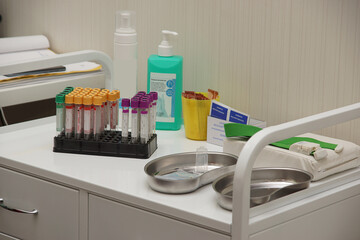 A table in the doctors office with many disinfectants and a set of test tubes
