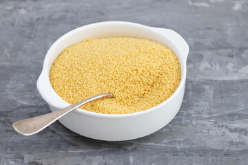 couscous in white bowl on grey ceramic background