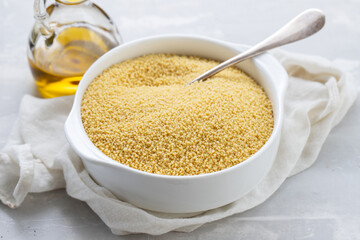 couscous in white bowl on grey ceramic background