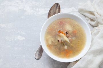 fish soup in white bowl on ceramic background