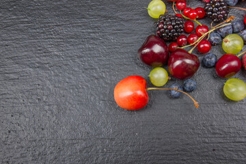 Various summer Fresh berries in a bowl on rustic wooden table. Antioxidants, detox diet, organic fruits. Top view