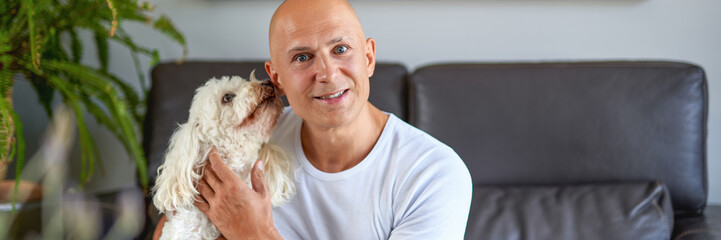 Man with cute white dog at home