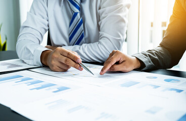 businessmen and businesswomen team pointing to charts meeting to plan strategies to increase business income. Have a brainstorming graph analysis and discussing for the new target success