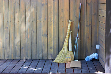 brooms and rakes on the threshold of a wooden house