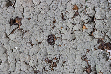 Peeling paint on the wall. Old concrete wall with cracked flaking paint. Weathered rough painted surface with patterns of cracks and peeling. Grunge texture for background and design. High resolution.