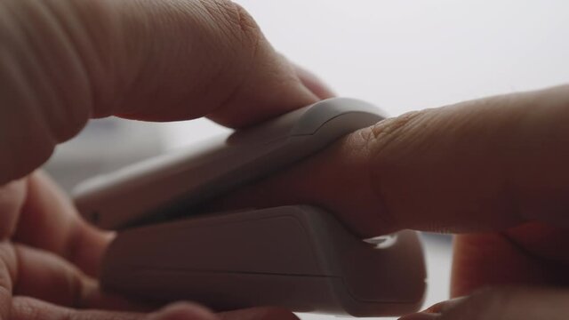CLOSEUP: Man using Oximeter at home
