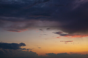 Fototapeta na wymiar Black thunderclouds at sunset. Bright orange sunset and dark clouds. Storm sky