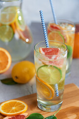 Homemade citrus water with grapefruit, orange, lemon and lime and ice in glass