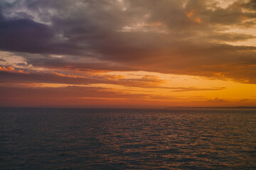 Naklejka na ściany i meble Multicolored red sky at sunset on the sea