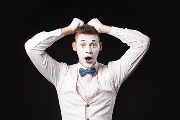 Man mime show emotion on isolated black background 