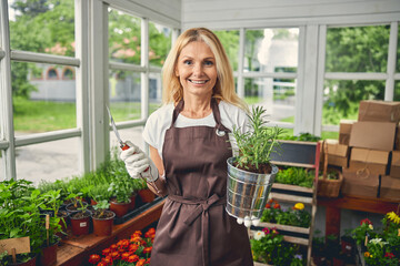 Smiling female botanist holding a rosemary seedling