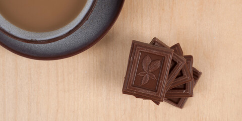 Chocolate and cup of coffee espresso on wood background