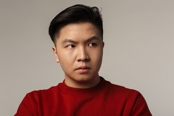 Image of displeased young asian man posing and looking aside