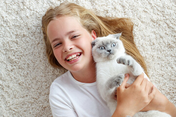 A child with a cat at home. Little girl with an animal.