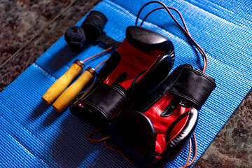 boxing gear ready to start training, black and red boxing gloves, leather skipping rope, black...