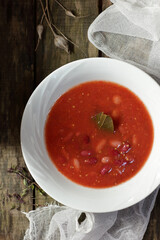 Vegan protein meal with red kidney bean and tomato sauce in white bowl flat on rustic table, overhead from above top view, vegetarian food concept