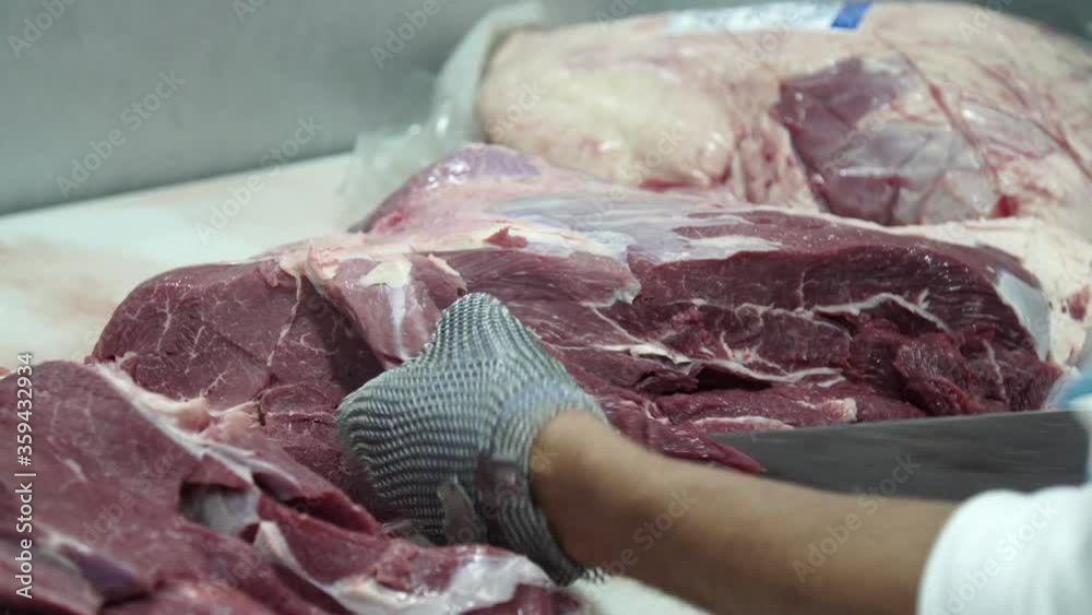 Wall mural Butcher cutting meat with metal gloves