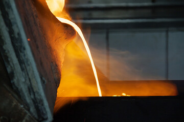 Gold smelting at a metallurgical plant. Liquid gold pouring into bowls to transfer gold to gold...