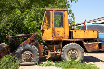 Fototapeta na wymiar old rusty broken wheel loader with a flat tire