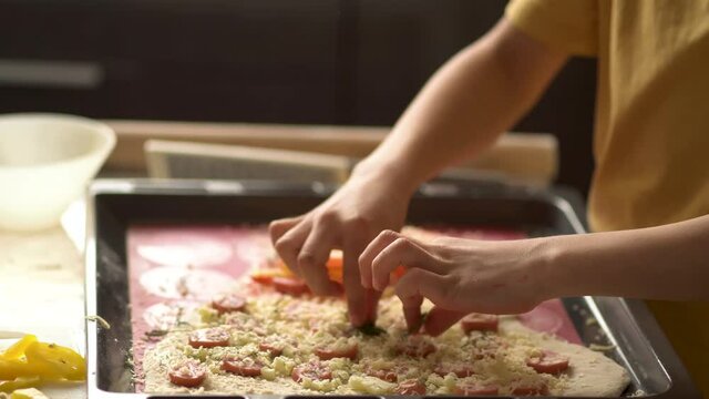 Children cooks pizza. Boy helps father. Prepering ingredients for pizza. Dad rubs cheese on a grater