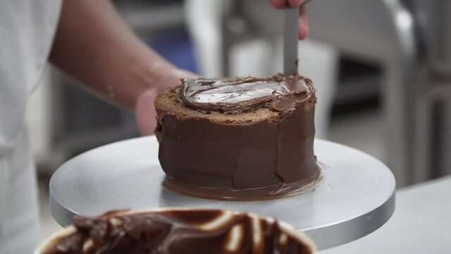 Confectioner using hands to make chocolate cake