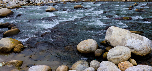 Fototapeta na wymiar flowing river having rocks in the river