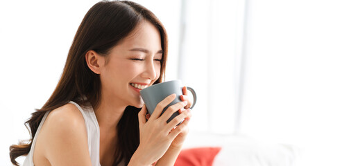 Portrait of smiling happy cheerful beautiful pretty asian woman relaxing drinking and looking at...