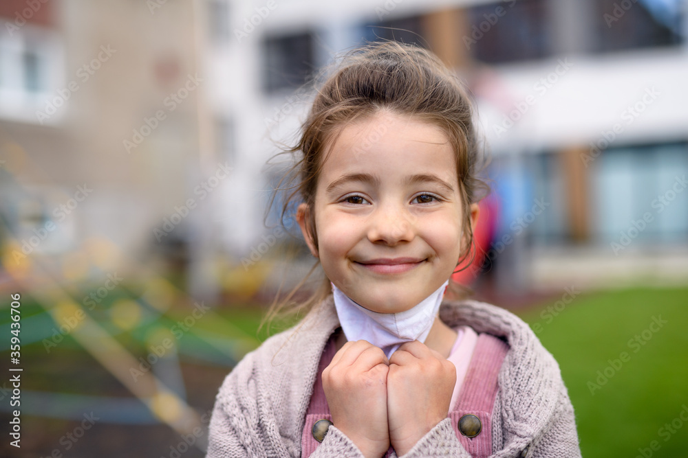 Poster portrait of happy child with face mask going back to school after covid-19 lockdown.